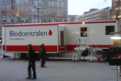 En lastbilstrailer i vitt och rött med texten Blodcentralen och en avbildad bloddroppe på står uppställd på Sergels Torg.