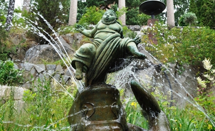 Carl Milles skulptur Jona i valfiskens buk med inbyggd fontän och naturskön omgivning.