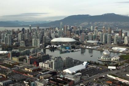 Vy över Vancouvers skyskrapor med olympiastadion med vitt tak i centrum.  Foto: City of Vancouver.