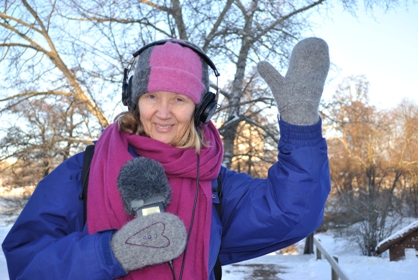 Åsa Nilsson är vinterklädd i mössa jacka och vantar. Hon vinkar.