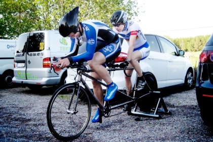 Två cyklister med hjälmar på tandemcykel