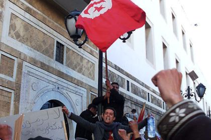 Demonstration i Tunisien. Vi ser knutna nävar och en tunisisk flagga