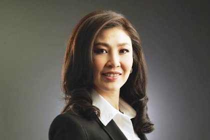 Yingluck Shinawatra har halvlångt svart hår, mörk kavaj och vit skjorta.