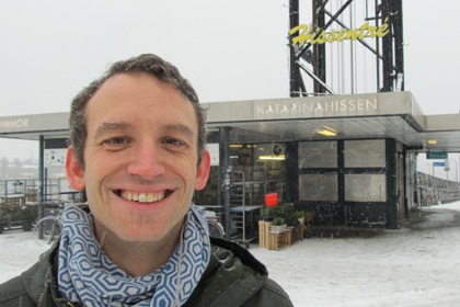 Thomas Örn arkivarie på Stockholms stadsmuseum står framför Katarinahissen. Han har korklippt mörkt hår och är iklädd en mörkgrön jacka och en gråblå mönstrad halsduk.