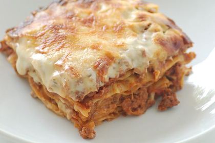 En bit lasagne färdig att ätas.