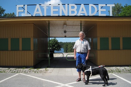 Guy Perdhe i solen framför Flatenbadets entré