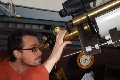 Peter Brandén tillförordnad chef på Observatoriemuseet tittar i en stjärnkikare