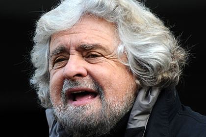 Beppe Grillo har tjockt, lockigt vitt hår som täcker öronen och vitt skägg.