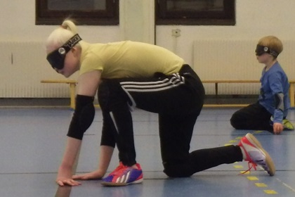 En av Goalballspelarna sitter i position och väntar på spelet.