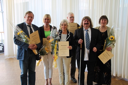 Fem pristagare fotas tillsammans med Håkan Thomsson, ordförande i SRF. De håller blommor och ler.