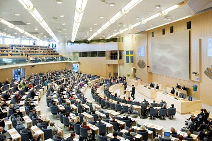 Riksdagsledarmöter som sitter och lyssnar på två debattörer inne i Sveriges riksdag.