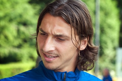 Vi ser Zlatan Ibrahimovic på bild. Han bär en blå tröja och har axellångt mörkbrunt hår.